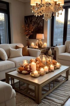 a living room filled with white couches and candles on top of a coffee table