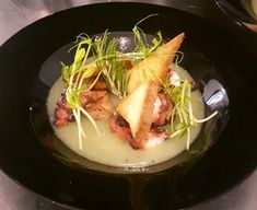 a black plate topped with food on top of a table