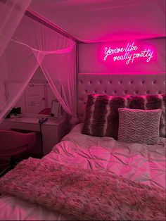 a bed with pink lights and pillows in a room