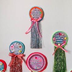 four different types of brooches with ribbons and tassels attached to them