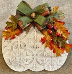 two pictures of fall wreaths with bows and leaves on the top one is made out of wood