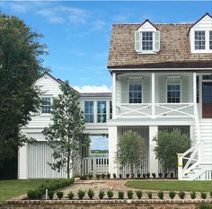 a large white house sitting next to a lush green field