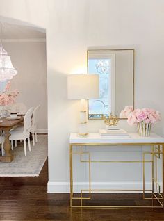 a dining room table with flowers on it and a chandelier hanging from the ceiling