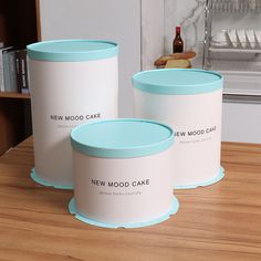 two new mood cake canisters sitting on a table