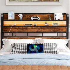 a bed with a laptop sitting on top of it next to a wall mounted painting