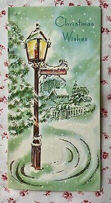 an old fashioned christmas card with a street light and snow covered trees in the background