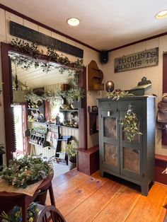 a room with wooden floors and lots of plants on the shelves in front of it