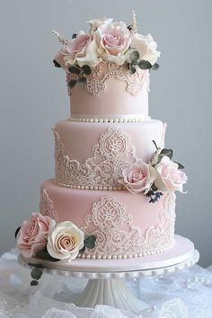 a pink wedding cake with white flowers on top