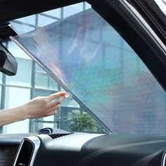 a person is holding their hand out to the driver's side window in a car