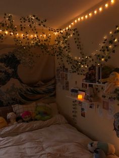 a bedroom with lights strung from the ceiling and pictures on the wall above the bed