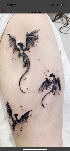 a black and white photo of a dragon tattoo on the back of a woman's shoulder