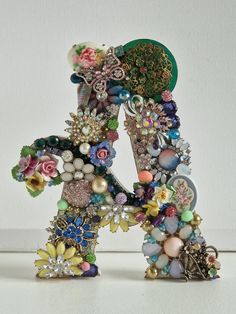 the letter k is made up of many different types of beads and flowers on it