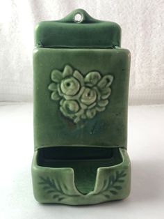 a green soap dispenser sitting on top of a white table