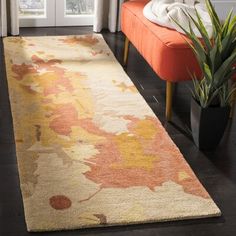 an orange and yellow floral rug in a living room