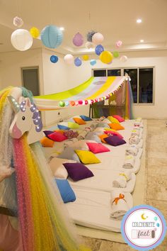 a room filled with lots of colorful pillows and decorations hanging from the ceiling above it