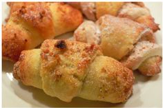 several pastries on a white plate with powdered sugar