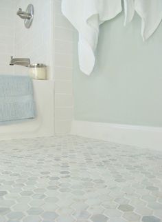 a bathroom with white and gray tiles on the floor