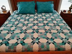 a bed with green and white quilt on it