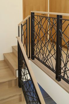 a staircase with metal railing and wooden handrails