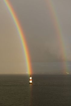 two rainbows in the sky over an ocean