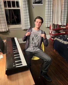 a young man sitting in front of a piano