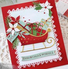 a handmade christmas card with a sleigh and presents on it's side