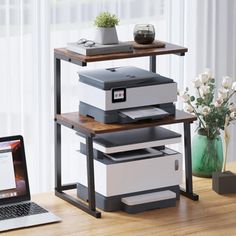 a laptop computer sitting on top of a wooden desk next to a printer and printer tray