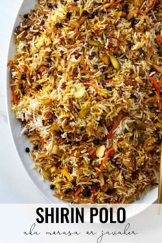 a white plate topped with rice and veggies next to chopsticks on a table