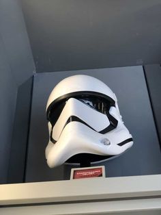 a helmet is on display in a glass case with other items around it, including a star wars mask