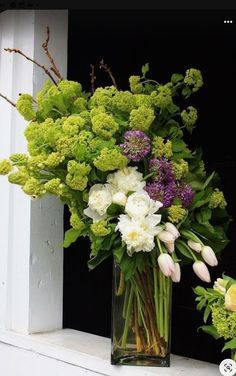 a vase filled with flowers sitting on top of a window sill