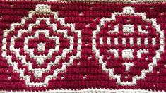 a close up of a red and white crocheted blanket with flowers on it