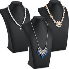 three necklaces are displayed on mannequins with pearls and other jewelry items