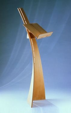 a wooden book stand on a blue background with light coming through the top and bottom