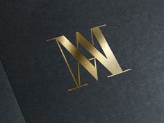 the letter w is made out of gold foil and has a black background with golden lettering