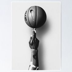 a person holding a basketball up to the air with their hand on top of it