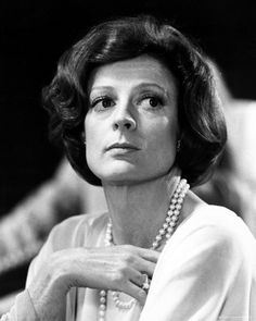 an old photo of a woman with pearls on her neck and hands folded in front of her