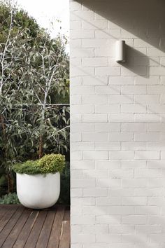 a white planter sitting on top of a wooden deck