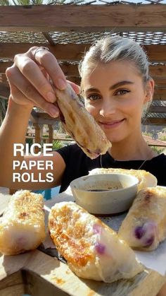 a woman is holding up some food to her face with the words rice paper rolls in front of her