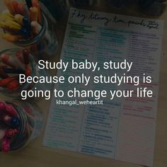 a baby is sitting in front of a book and some crayons on the table