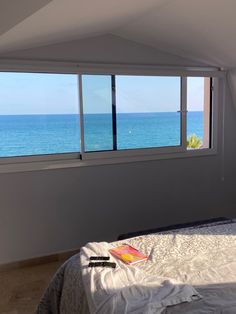 a bedroom with a large window overlooking the ocean