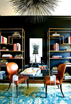 a living room filled with furniture and bookshelves next to a wall mounted book shelf