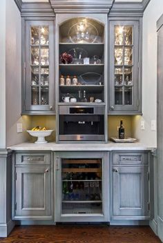 a kitchen with gray cabinets and white counter tops