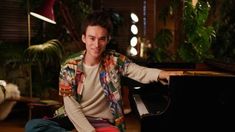 a young man sitting at a piano posing for the camera