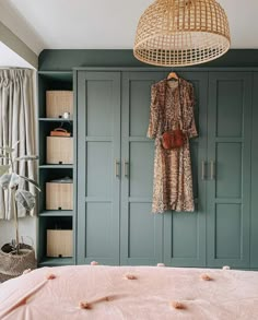 a bedroom with green painted walls and wooden furniture, including a bed in front of a wicker basket hanging from the ceiling