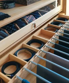 an organized drawer with ties in it