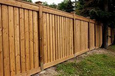 a wooden fence in the middle of a yard