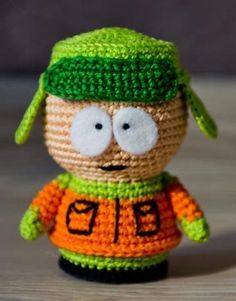 a crocheted toy with a green hat and orange shirt