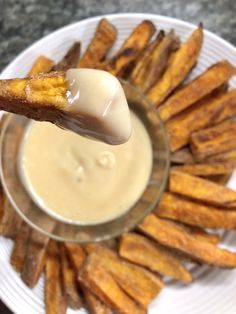 french fries on a plate with dipping sauce in the middle, ready to be eaten