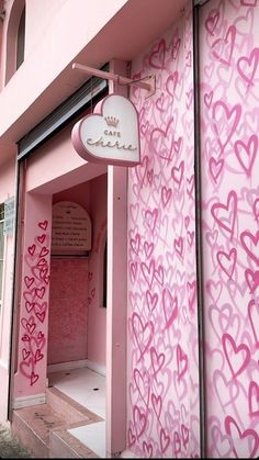 a pink building with lots of hearts painted on the outside and inside it's doors