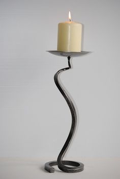 a candle that is on top of a metal stand with a white candle in it